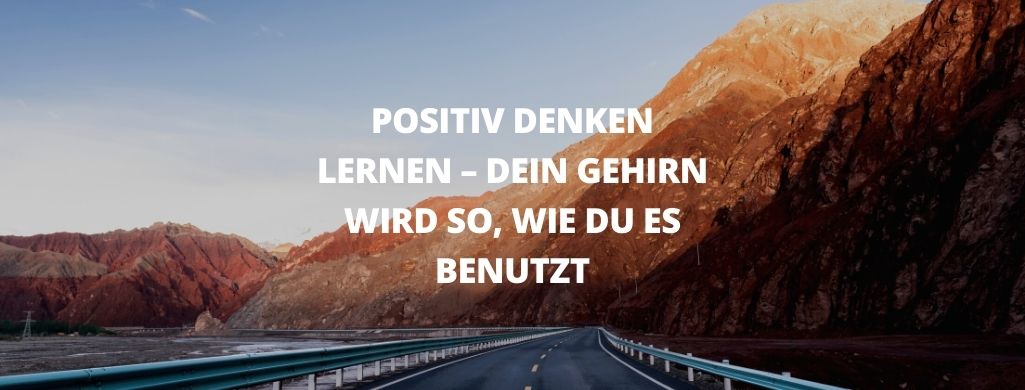 Eine Autobahn führt eine Landstraße entlang, im Hintergrund Felsen im Abendrot